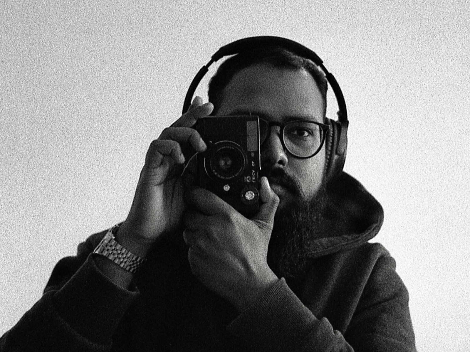 Self portrait of Joshua Wilfred Sekar holding a rangefinder camera