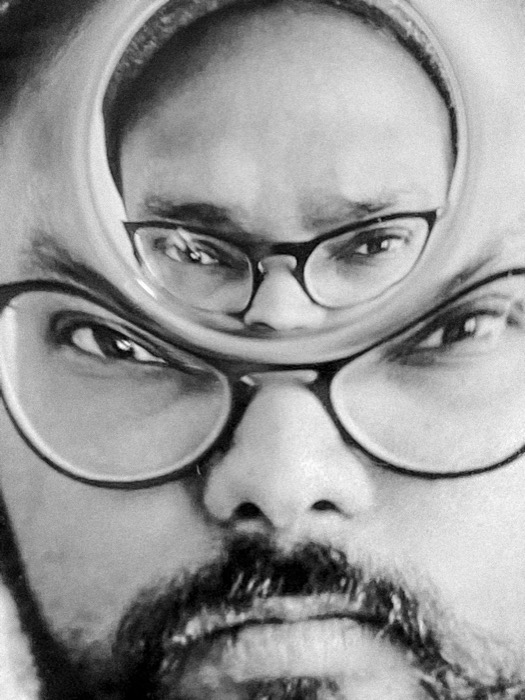 Distorted double self-portrait, a bearded man's bespectacled face repeated inside a bubble over his own eyes