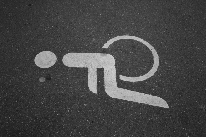 Road marking on asphalt of a cyclist pictogram, reduced to abstract white shapes