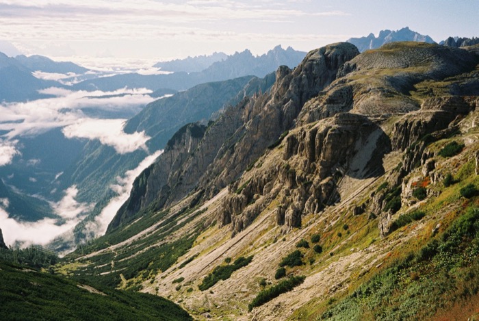 View along a jagged mountain ridge to a valley filled with low cloud