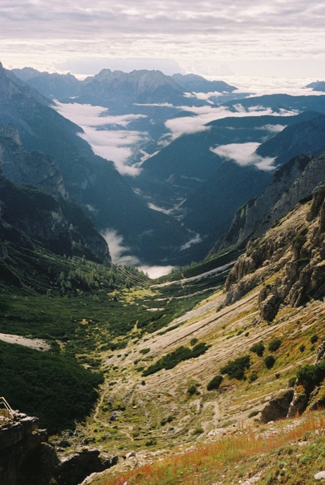 Deep mountain valley seen from above, low cloud lying between the ridges